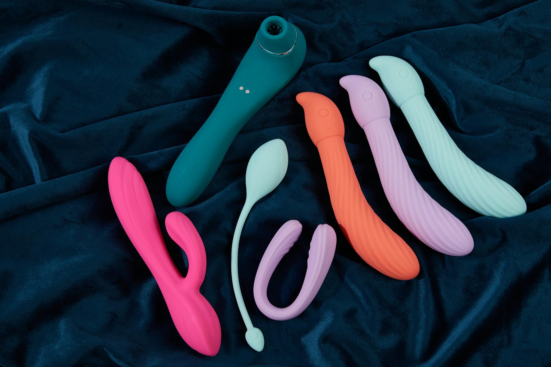 A young couple standing together indoors, holding a blue vibrator, symbolizing modern intimacy and shared exploration.