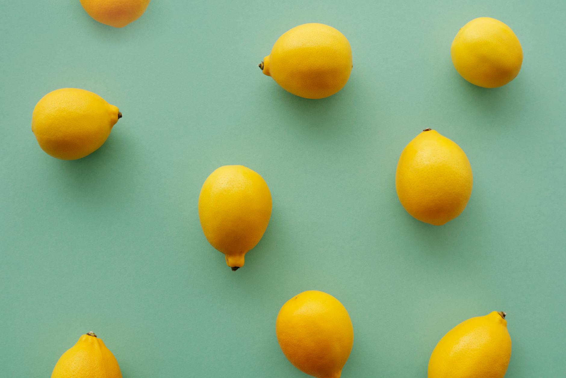 Bright yellow lemons arranged on a pastel background, symbolizing the cyclical rhythm of pleasure and sensitivity.