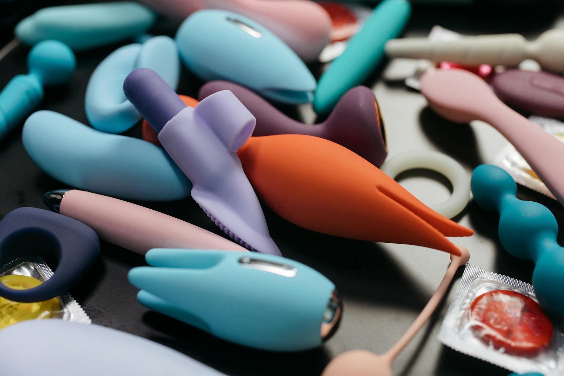 Colorful vibrators and pleasure devices displayed on a bright yellow surface