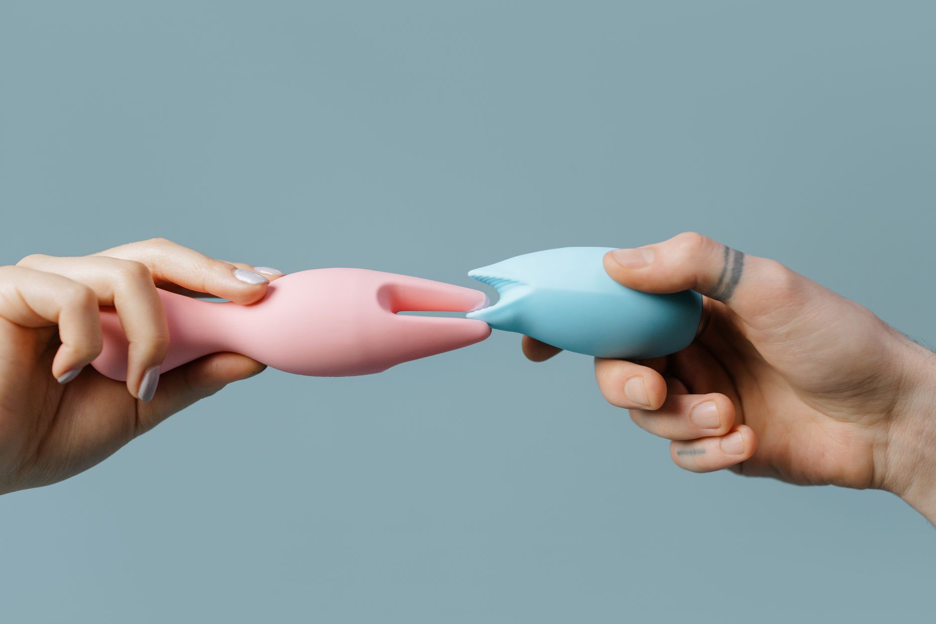 Mujer sosteniendo vibradores de colores con tranquilidad y confianza