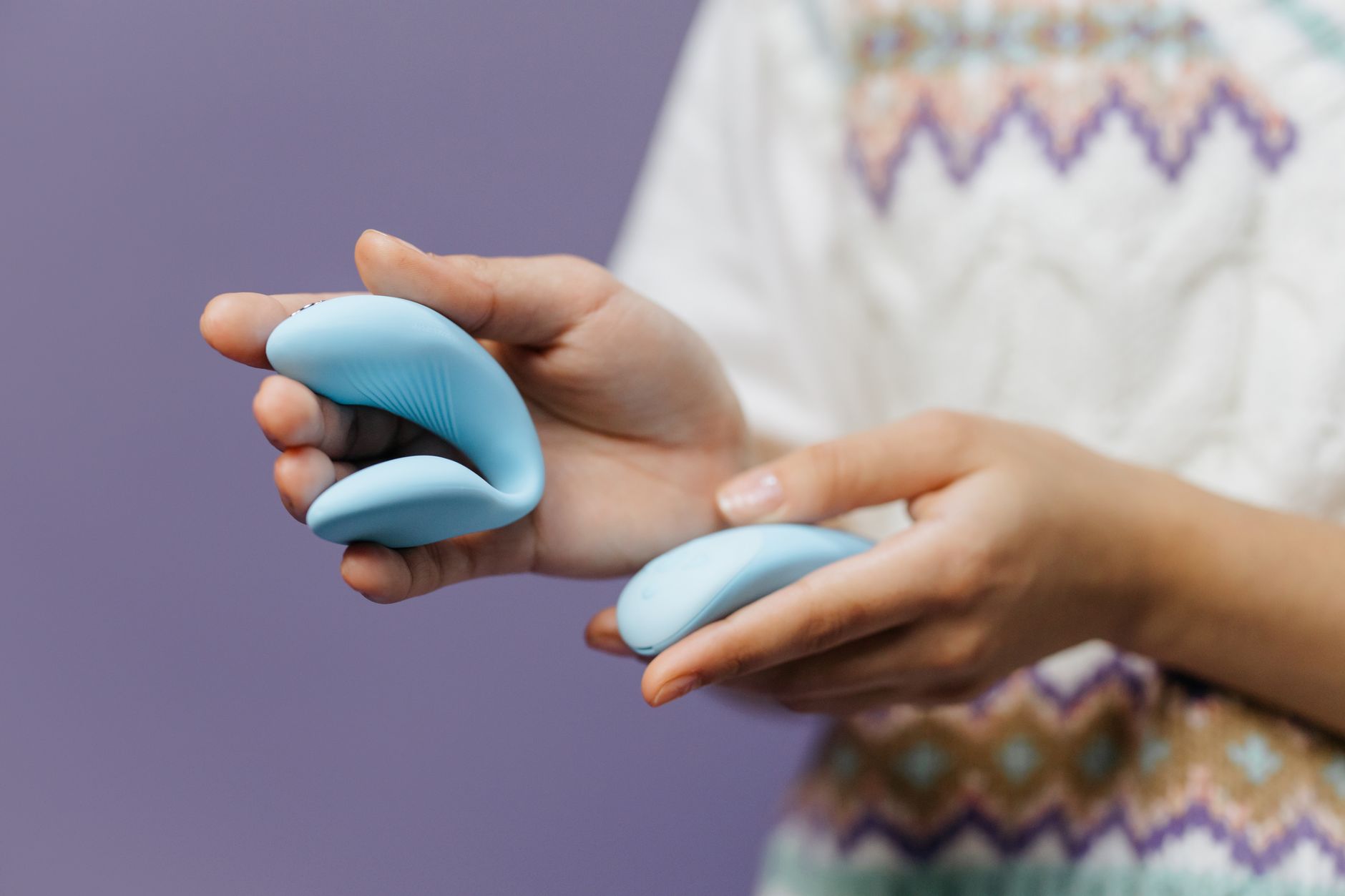 Hand holding a sleek blue lemon vibrator against a textured background, symbolizing the tool for pleasure recovery
